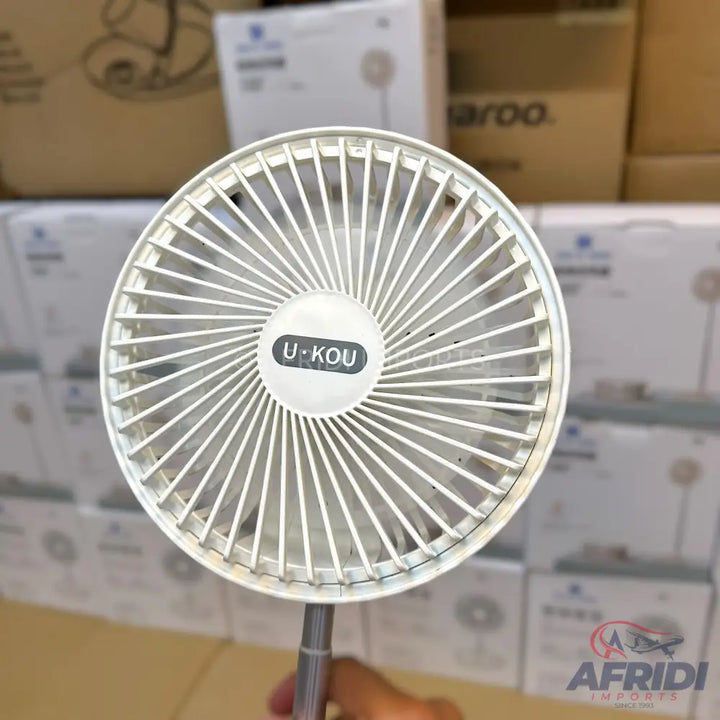 White portable electric fan with a retractable handle.