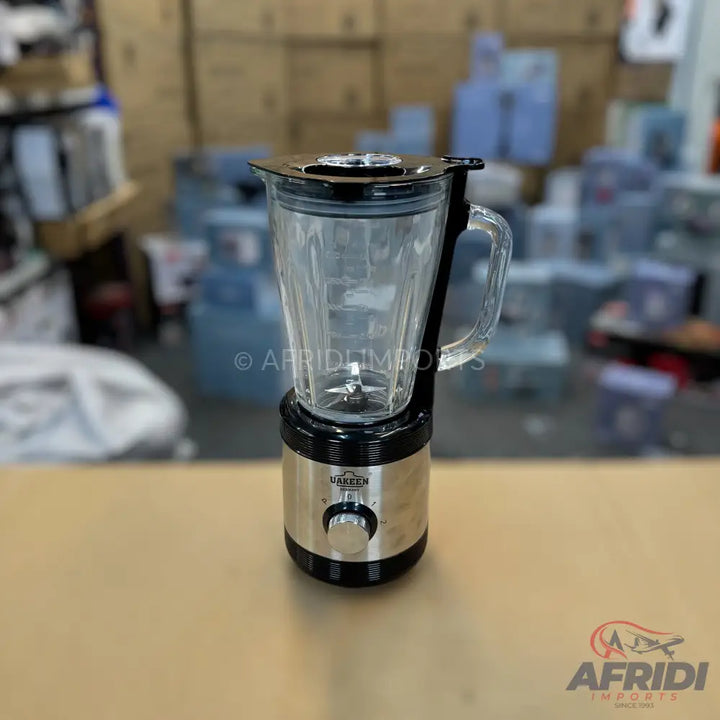 A stainless steel and glass blender with a black base and lid.