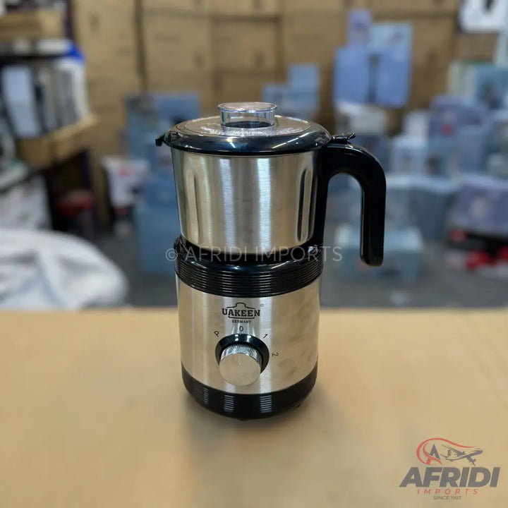 Stainless steel blender with a clear top and black handle.