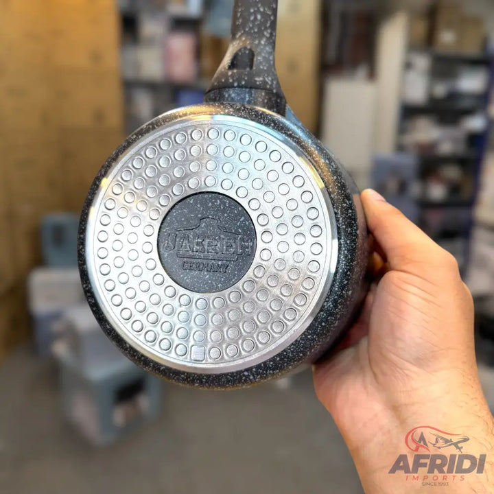 The bottom of a speckled black and grey non-stick frying pan with a textured, silver-toned base.