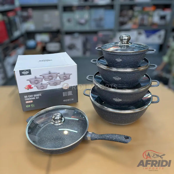 A set of black speckled, non-stick, cast granite cookware with glass lids.