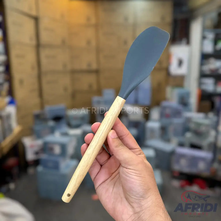 A silicone spatula with a wooden handle.