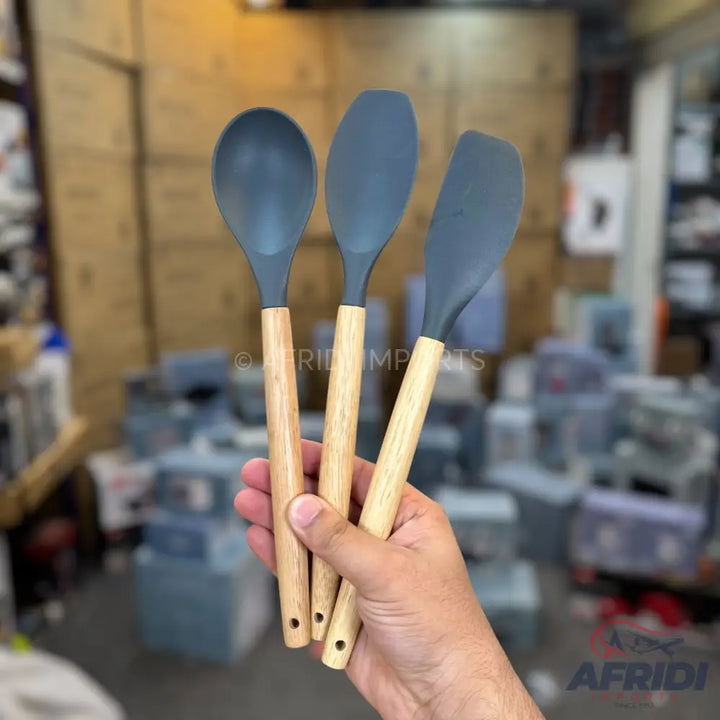 Set of three silicone kitchen utensils with wooden handles.