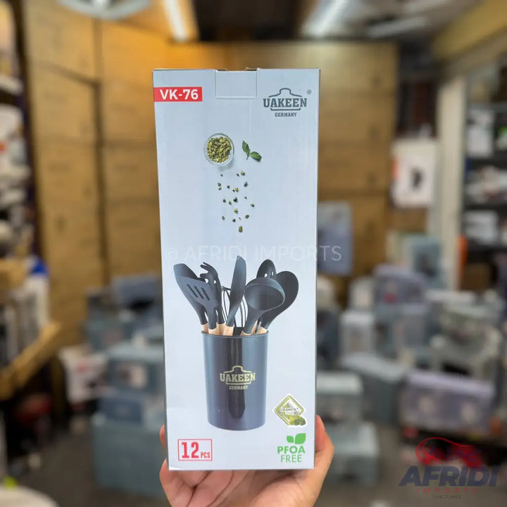 A boxed set of 12 black silicone kitchen utensils with wooden handles, including a holder, and labeled as PFOA-free.