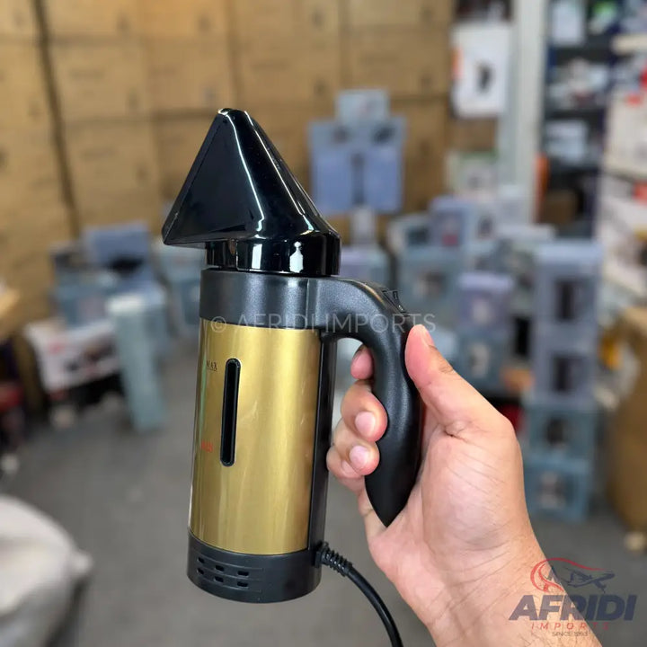 A handheld garment steamer with a gold-colored body and black handle.