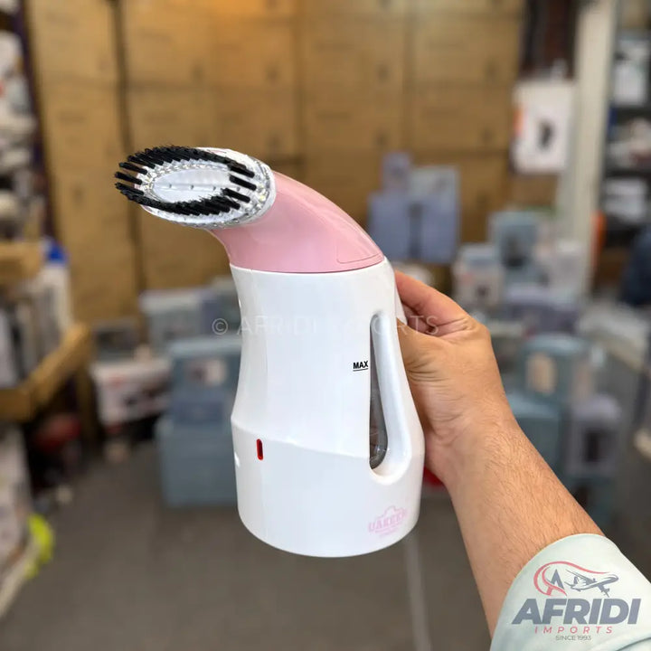 A white and pink handheld garment steamer with a brush attachment.