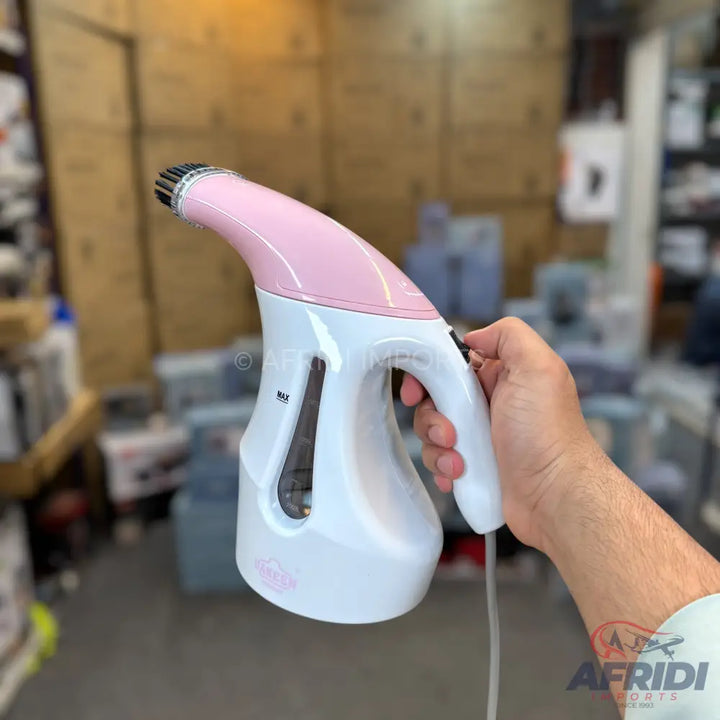 Pink and white handheld garment steamer with a clear water tank and an ergonomic handle.