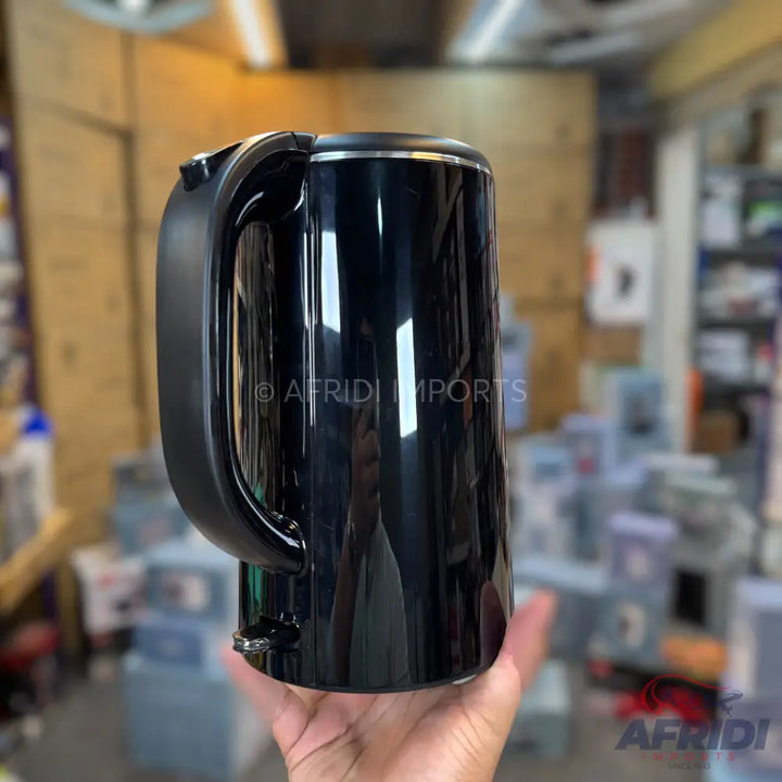 Shiny black electric kettle with a curved handle.