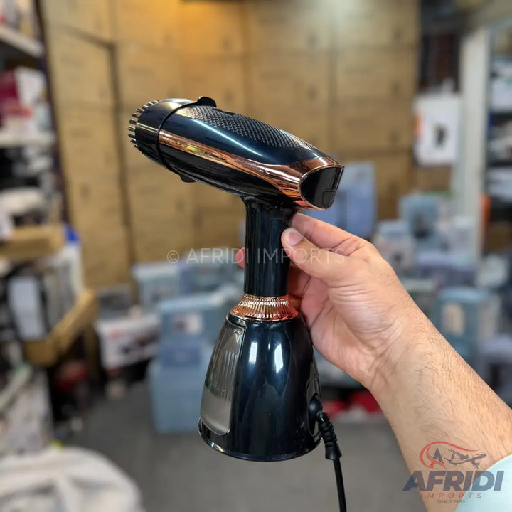 Black and rose gold handheld garment steamer.