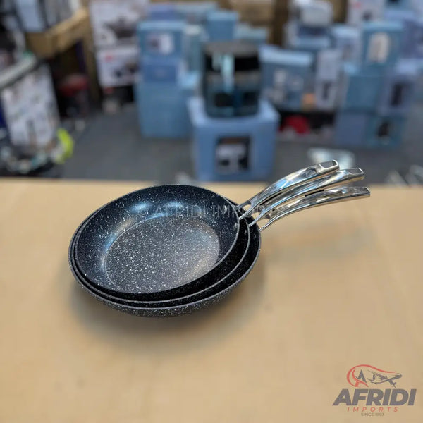 A stack of three non-stick frying pans with speckled black interiors and metallic handles.