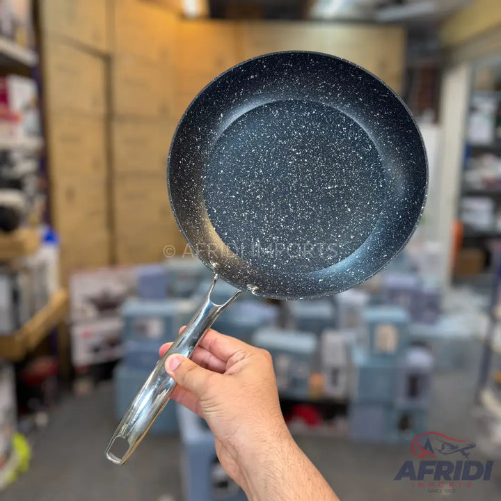 A dark gray speckled non-stick frying pan with a metallic handle.