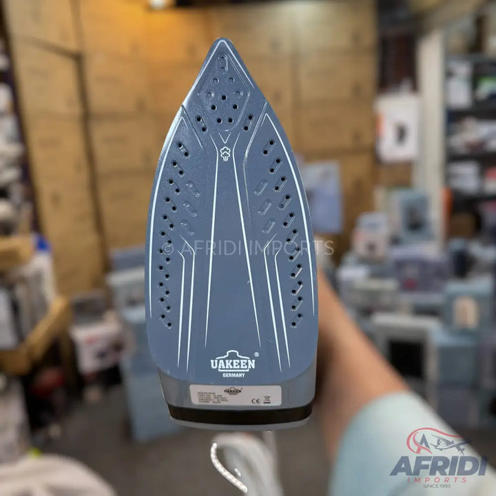 Gray steam iron with a textured soleplate.