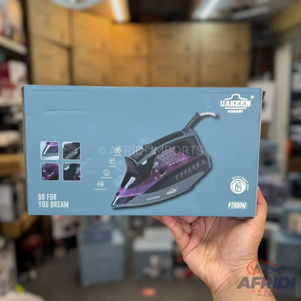A boxed black and purple steam iron with a ceramic soleplate and an auto-off feature, rated at 2890W.