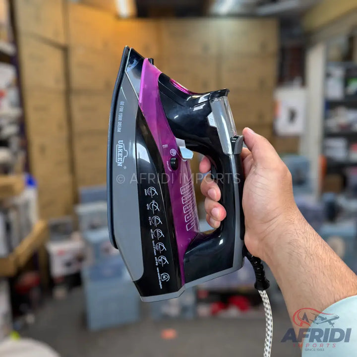 Black and purple electric steam iron with a grey soleplate.