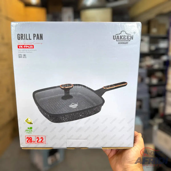 Packaged square grill pan with a glass lid and granite-effect coating.