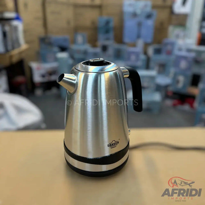 Stainless steel electric kettle with a black handle and base.
