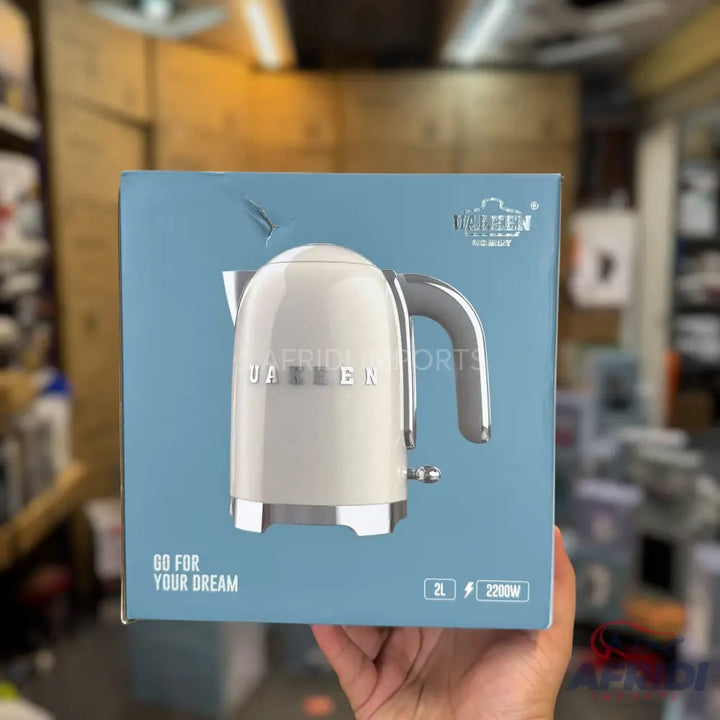 A cream-colored electric kettle with a chrome handle, 2L capacity, and 2200W power.