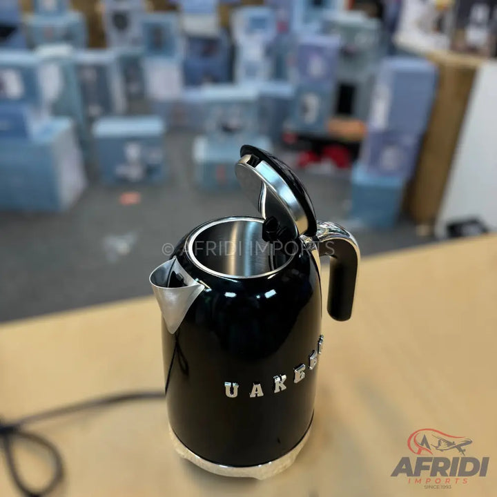 Black electric kettle with a stainless steel interior and a silver handle.