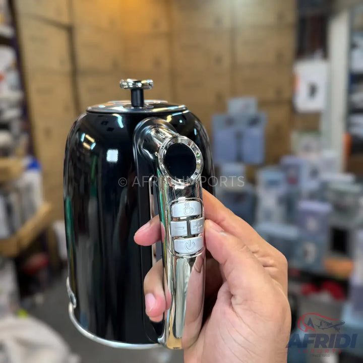 Black electric kettle with a chrome handle and temperature control buttons.