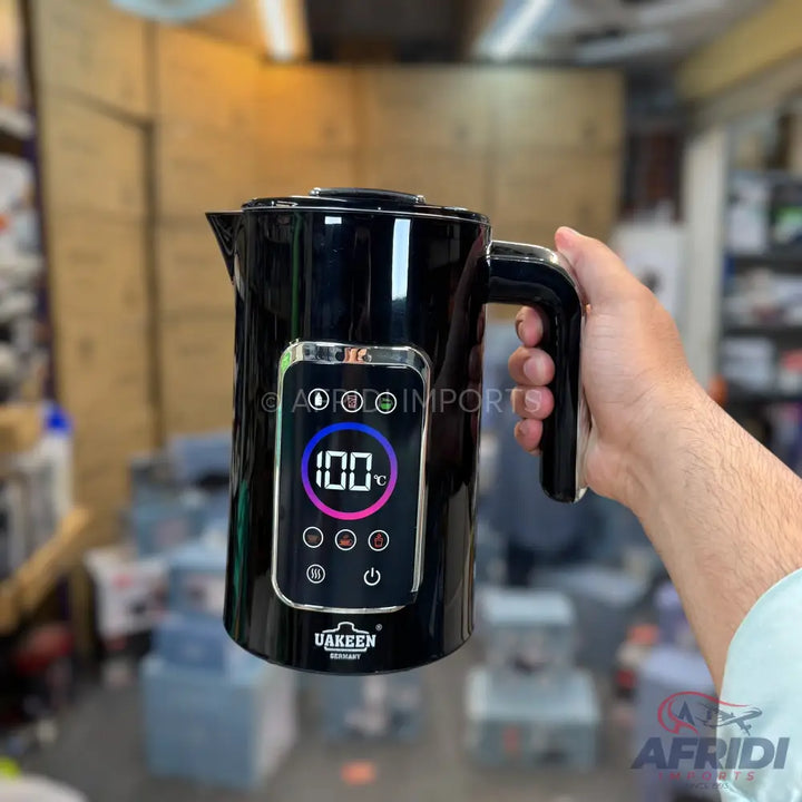 Black electric kettle with digital temperature display.
