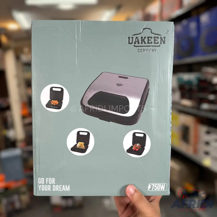 Boxed electric sandwich maker with interchangeable plates for waffles and grilled sandwiches.