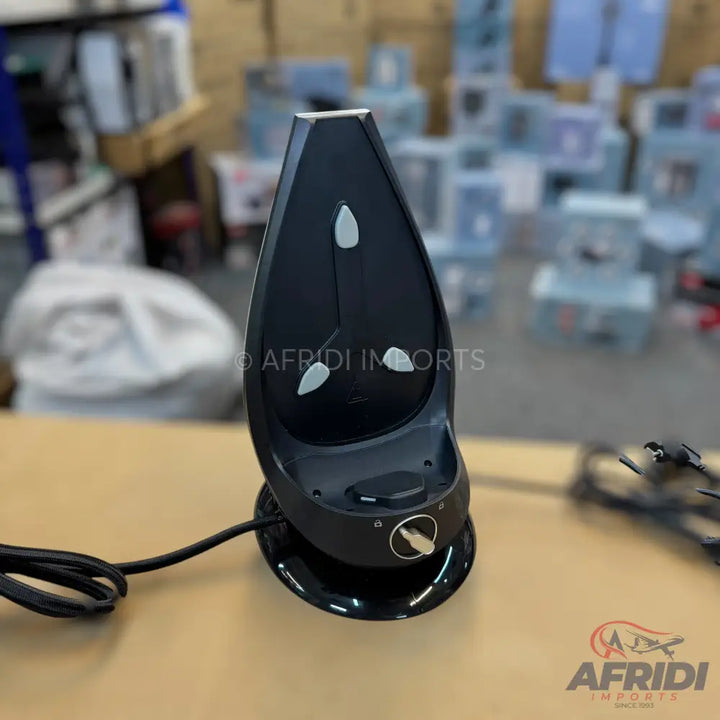 Black handheld barcode scanner with a charging base.