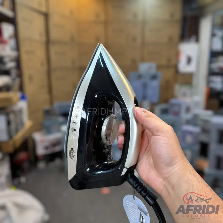 Black and silver electric steam iron with a non-stick soleplate.