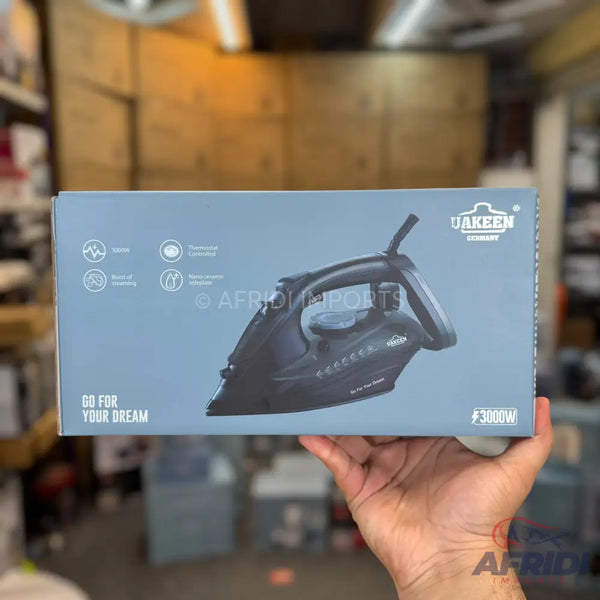 A dark grey steam iron with a black handle, featuring an anti-drip system, self-cleaning function, and a 3000W power rating.