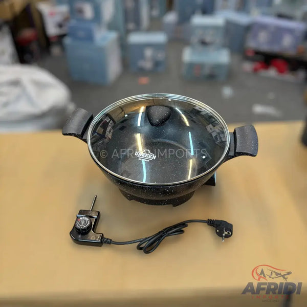 Black electric cooking pot with a glass lid and power cord.