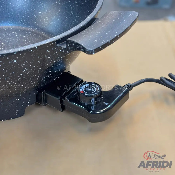 Black speckled electric cooking pot with a detachable temperature control.