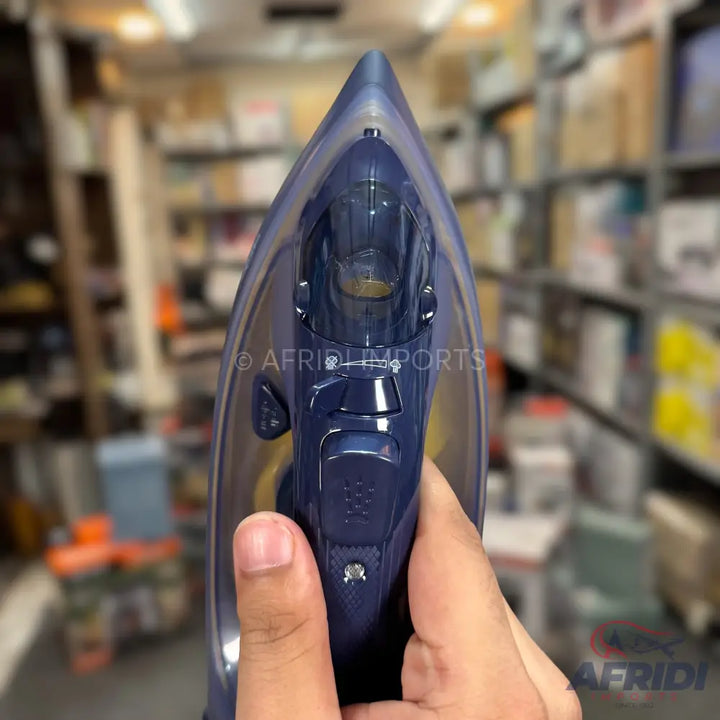 A dark blue handheld steam iron with a clear water tank.