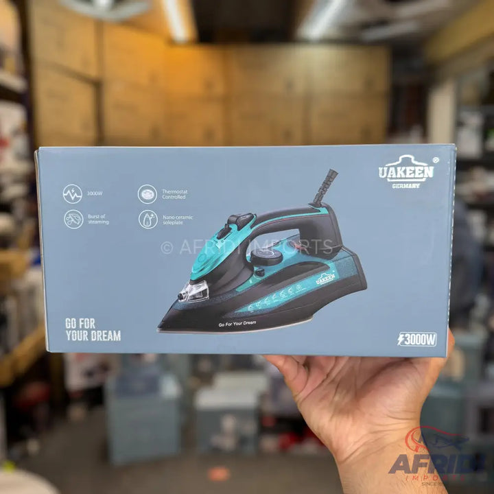 A black and teal steam iron with a 3000W power rating.