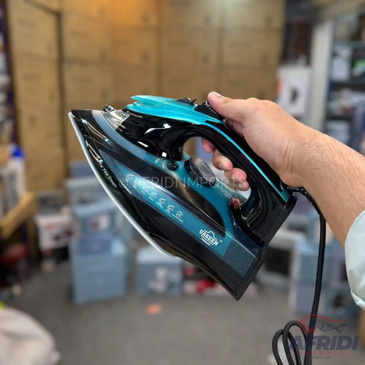 A black and teal steam iron with a textured soleplate.