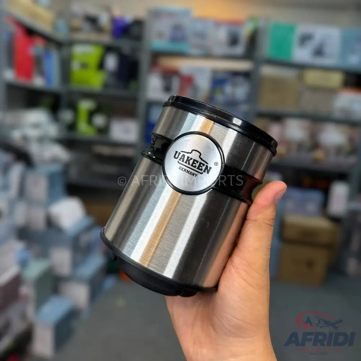 Handheld stainless steel thermal mug with a black lid.
