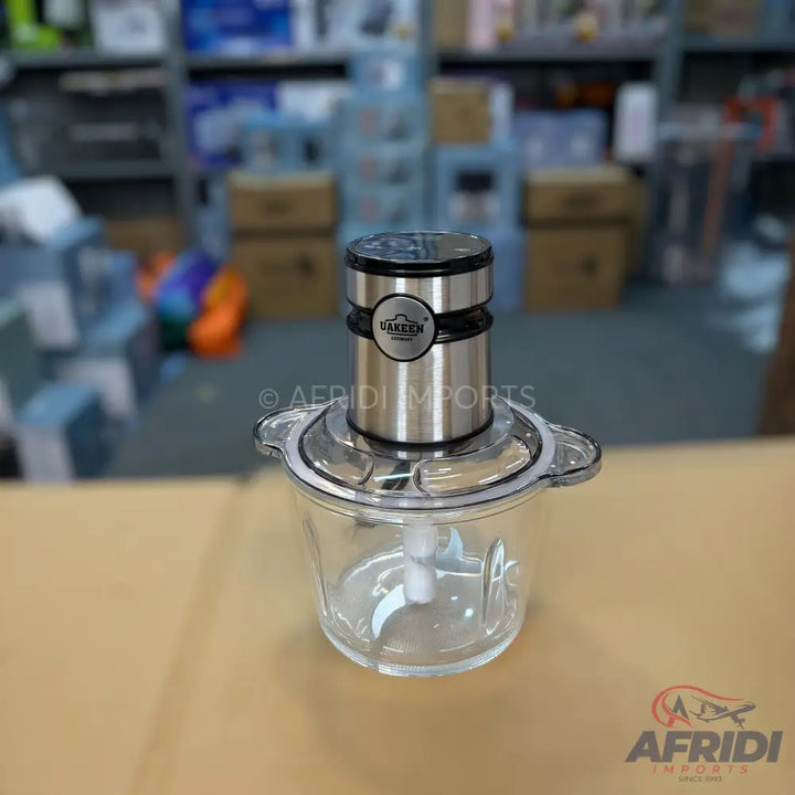 A compact, stainless steel and clear plastic food chopper with a powerful motor for efficient chopping.