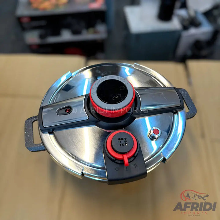 Stainless steel pressure cooker with black and red accents.