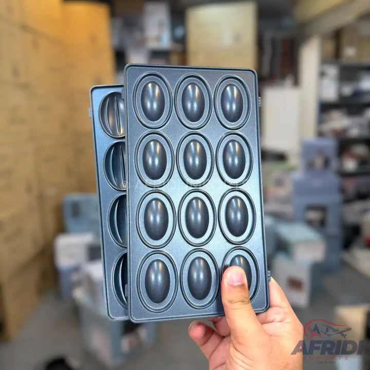 A pair of non-stick baking molds with oval cavities for making small cakes or cookies.