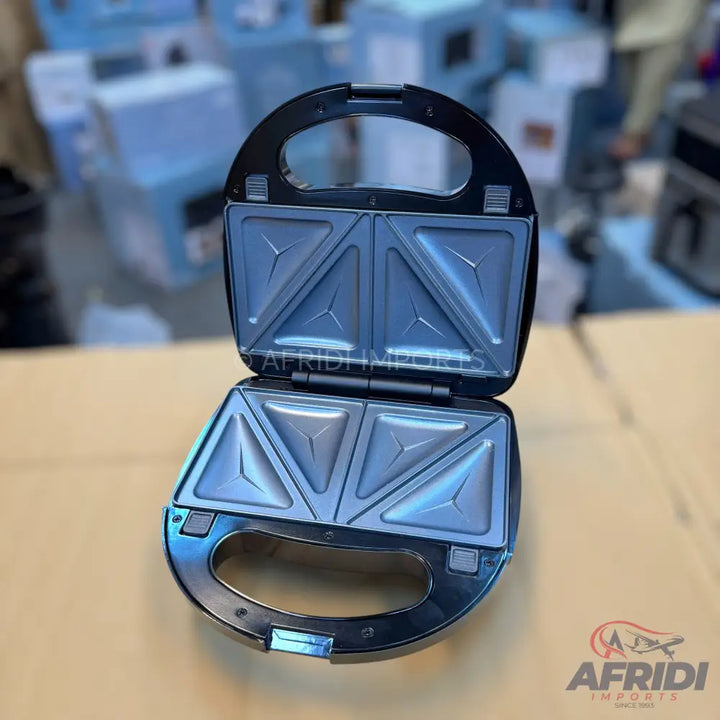 An open, black sandwich maker with triangular cooking plates.