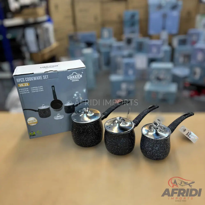 Black speckled cookware set with three pots and a box.