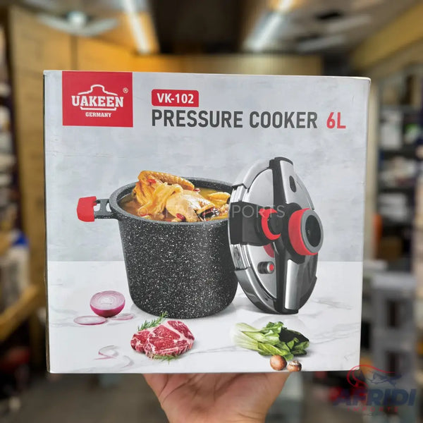 Pressure cooker with a speckled gray pot and a silver and red lid.