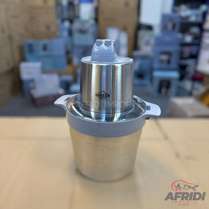 Silver stainless steel electric food chopper with a light grey plastic lid.