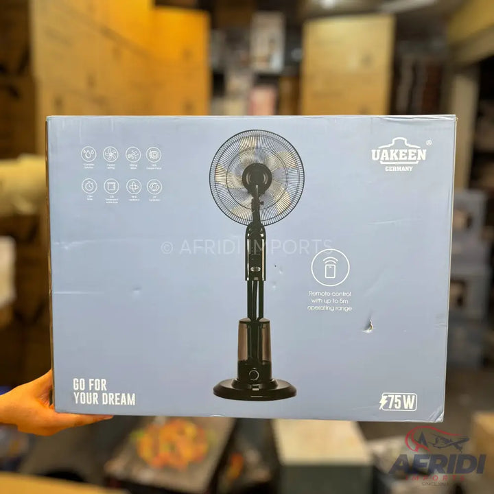 A black standing fan in a light blue box, with a remote control feature and a power rating of 75W.