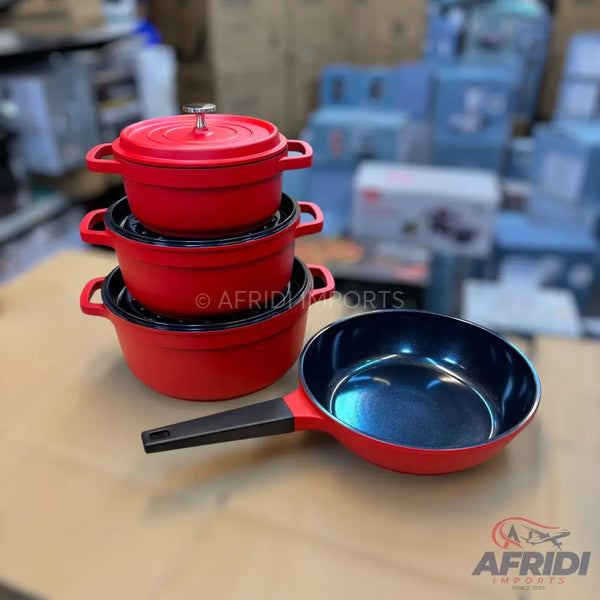 A set of red cast iron dutch ovens and a frying pan.