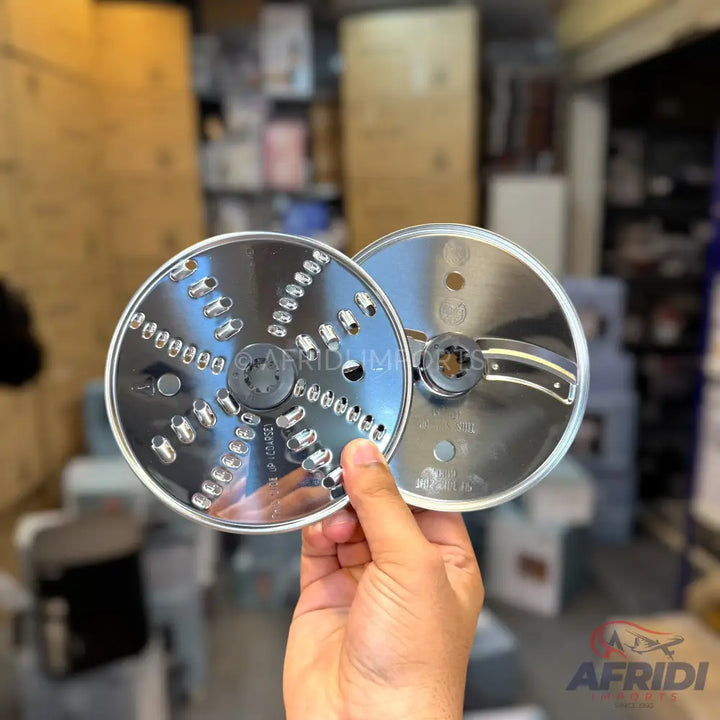 Two stainless steel grater and slicer discs for a food processor.
