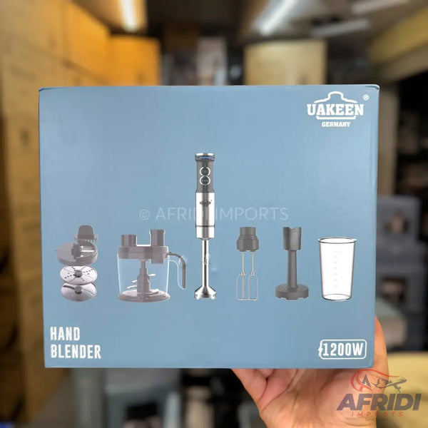 A blue box containing a UAKEEN Germany 1200W hand blender with various attachments including a chopper, whisk, and measuring cup.