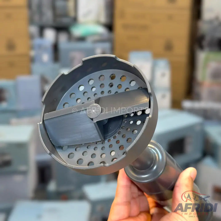 Handheld meat grinder attachment with a perforated plate and rotating blade.
