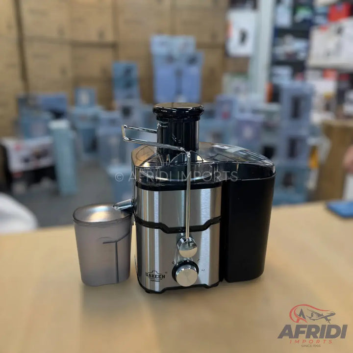 Stainless steel and black electric juicer with a clear juice collection cup.
