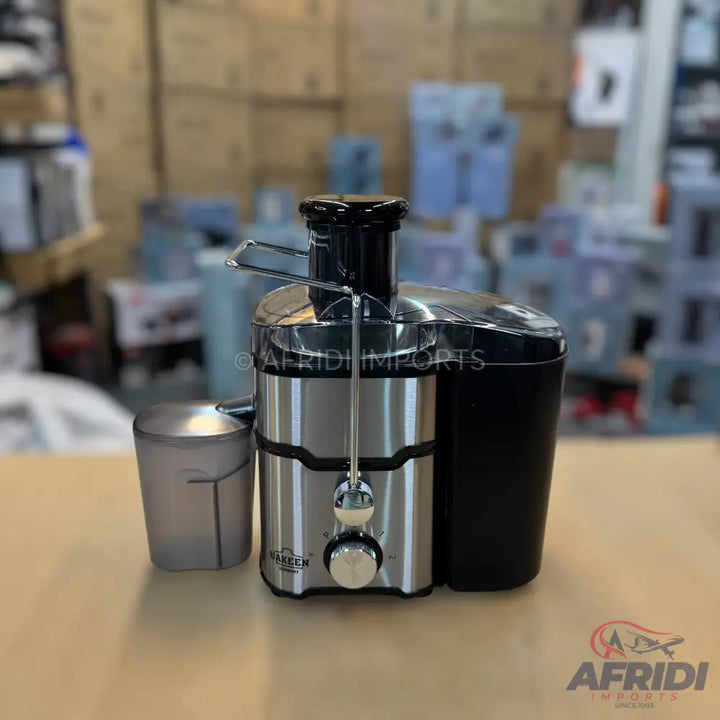 Stainless steel juicer with a black pulp container and a clear juice cup.