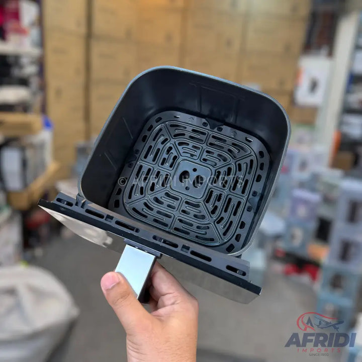Black air fryer basket with a square, perforated bottom.