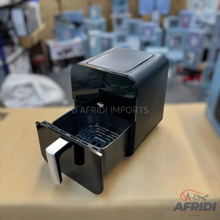 A black air fryer with an open basket and silver handle.
